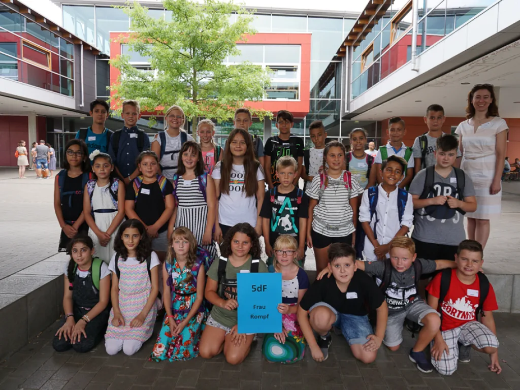 Klassenfoto einer neuen fünften Klasse vor dem Gebäude.